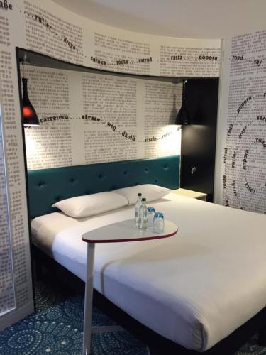 a room with two beds with a table in front of it at Ibis Styles Liverpool Centre Dale Street - Cavern Quarter in Liverpool