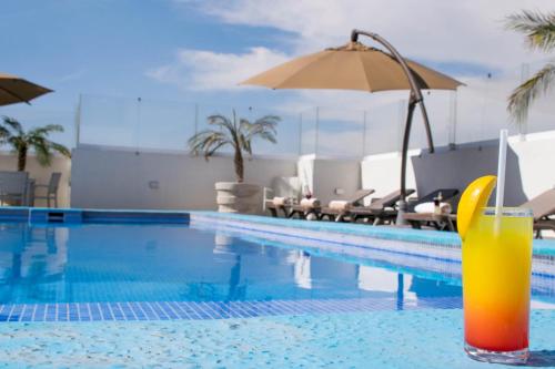 a swimming pool with an orange drink in the water at Hotel Stadium Leon in León