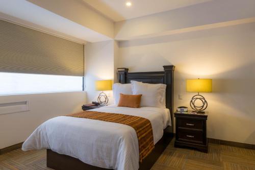 a bedroom with a bed with two lamps and a window at Hotel Stadium Leon in León