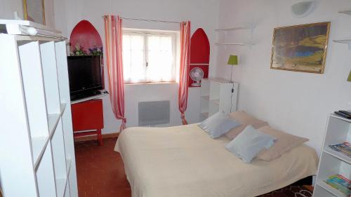 a small bedroom with a bed and a window at L'Estagnol in Le Castellet