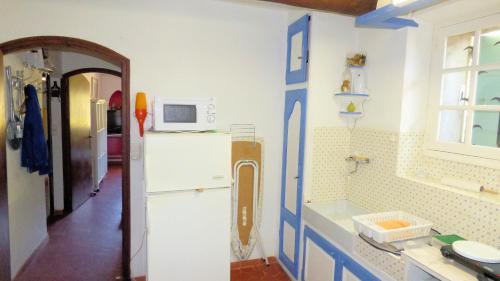 a kitchen with a white refrigerator and a microwave at L'Estagnol in Le Castellet
