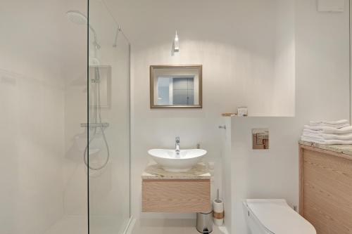 y baño blanco con lavabo y ducha. en TriApart Deluxe Przy Plaży (Beach Apartment), en Gdansk