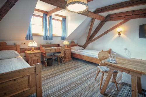 een slaapkamer met een bed en een bureau bij Landhotel Schlappinger-Hof in Reisbach