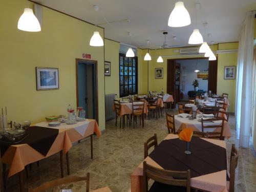 a dining room with tables and chairs and lights at Hotel Saturno in Chianciano Terme