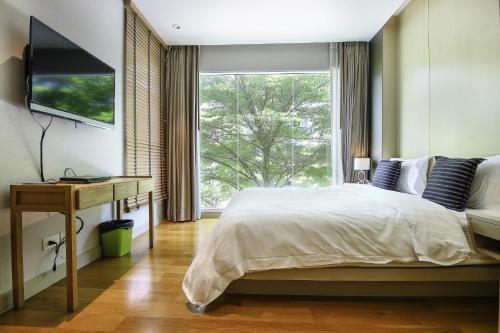 a bedroom with a bed and a large window at Residents Hua Hin by Wanida in Hua Hin