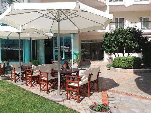 a table and chairs under an umbrella on a patio at Hotel Filoxenia Beach in Leptokaria