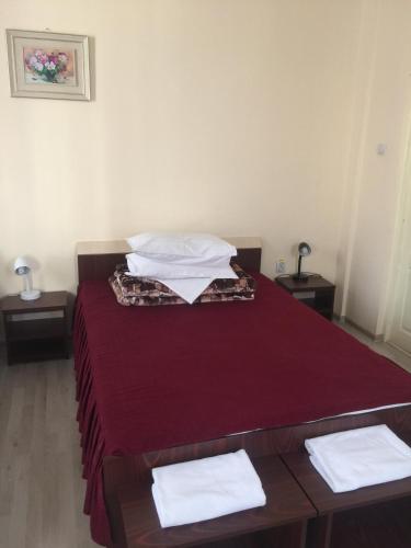 a bedroom with a red bed with two tables at Hotel Continental City Center in Iaşi