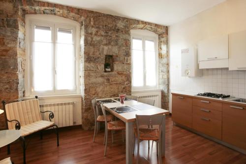 a kitchen with a sink and a table with chairs at Residence Theresia- Tailor Made Stay in Trieste