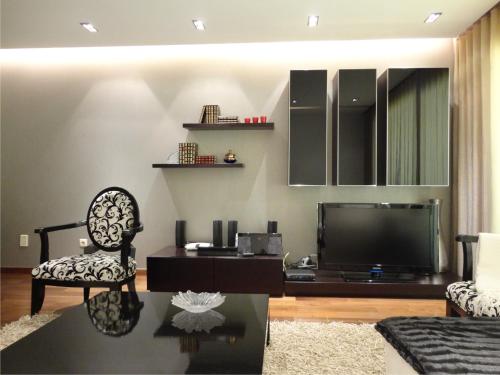 a living room with a tv and a chair at Dream Space Home in Leiria