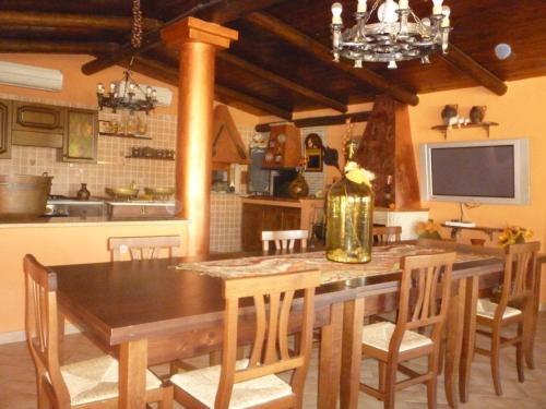 a dining room with a table and chairs and a television at Chalet Rustico in Sessa Aurunca