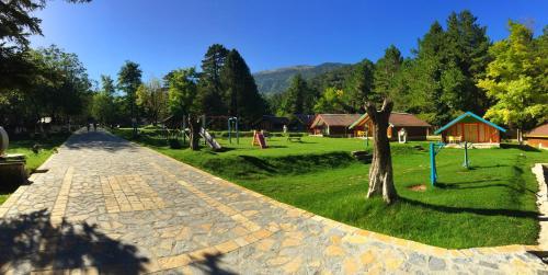 a cobblestone street in a park with a playground at Te'Dreri - Llogora Tourist Village in Dhërmi
