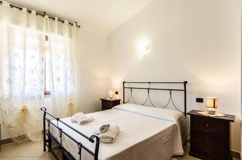 a bedroom with a bed with two towels on it at Azzurromare Casa Vacanze in Teulada