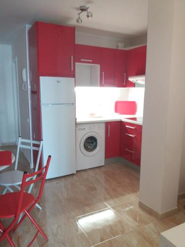 コラレホにあるApartamento en Corralejoのキッチン(赤いキャビネット、白い冷蔵庫付)