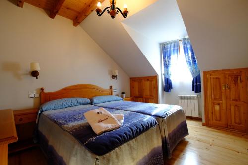 Un dormitorio con una cama con un edredón azul. en Hotel de Montaña Lamiana, en Lamiana