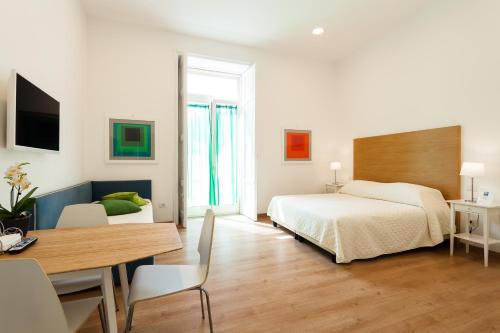 1 dormitorio con cama, mesa y comedor en Corso Italia Suites, en Sorrento