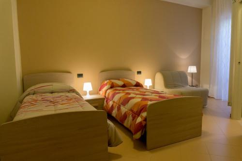 a bedroom with two beds and a couch and a chair at Il Viale in Chieti
