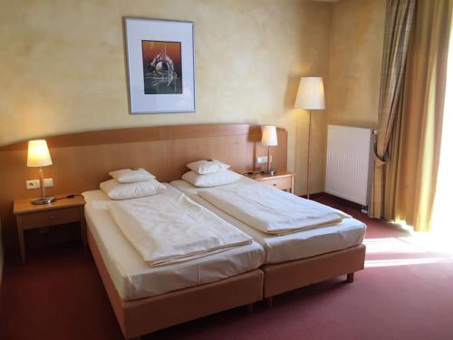 a hotel room with two beds and two lamps at Businesshotel HEILBRONN- Biberach in Heilbronn