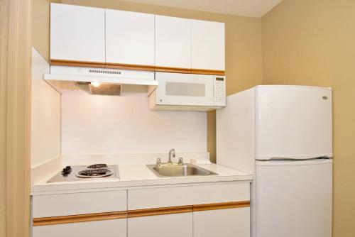 a white kitchen with a sink and a refrigerator at Extended Stay America Suites - Portland - Beaverton in Beaverton