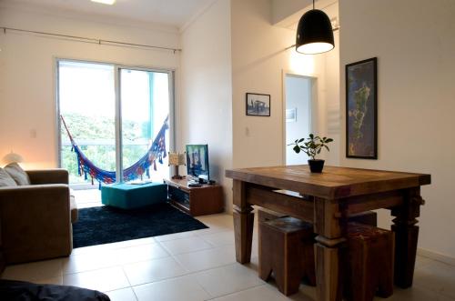 a living room with a table and a large window at Sea Front, Front Native Forest in Florianópolis