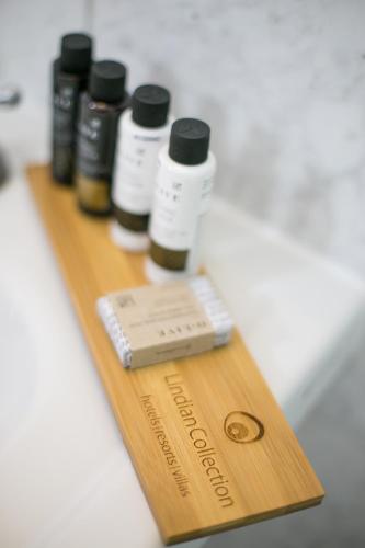 a wooden cutting board with five bottles of medicine at Thea Villas and Suite in Líndos