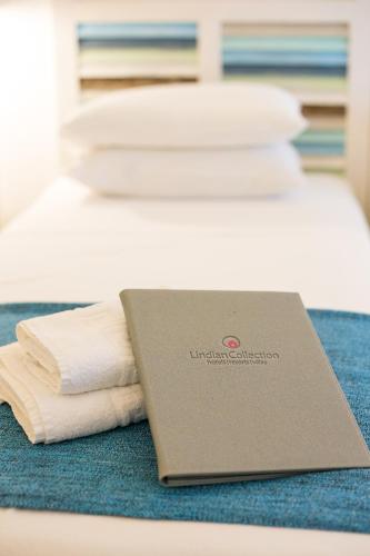a laptop sitting on top of a bed with towels at Thea Villas and Suite in Líndos