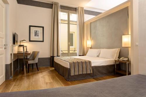 a hotel room with a bed and a desk at Hotel Orto de' Medici in Florence