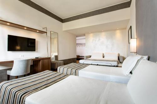 a hotel room with two beds and a television at Hotel Orto de' Medici in Florence