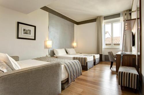 En eller flere senge i et værelse på Hotel Orto de' Medici