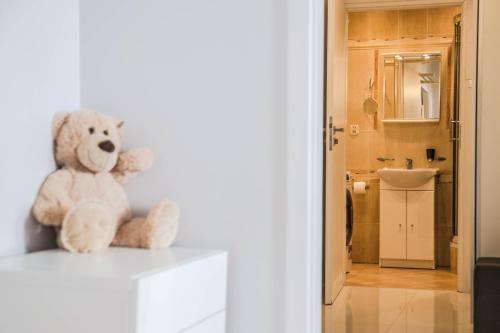 a teddy bear sitting on top of a white cabinet at Apartament Skwer Kosciuszki Gdynia Parking!! in Gdynia