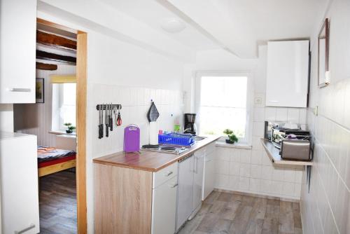 eine Küche mit weißen Wänden und einer hölzernen Arbeitsplatte in der Unterkunft Ferienwohnung Langelsheim in Langelsheim