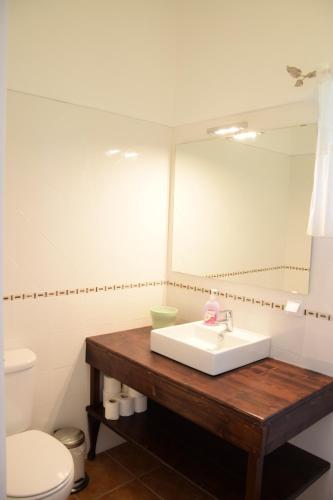 a bathroom with a sink and a toilet and a mirror at Casa da Paleta in Castelo de Vide