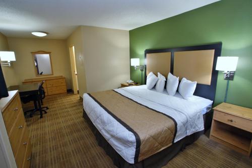a hotel room with a large bed and a desk at Extended Stay America Suites - Portland - Tigard in Tigard