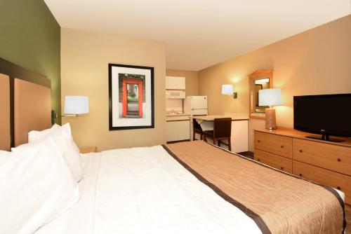 a hotel room with a large bed and a television at Extended Stay America Suites - Portland - Tigard in Tigard