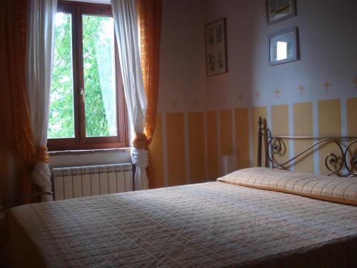 um quarto com uma cama grande e uma janela em Casale La Fornace em Costacciaro