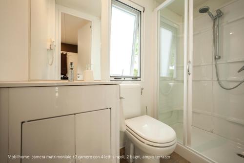 a white bathroom with a toilet and a shower at Camping Da Giovanni in Peschiera del Garda