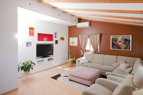 ein Wohnzimmer mit Couch und Fernseher in der Unterkunft Perla Alba Apartments in Tribunj