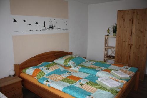 ein Schlafzimmer mit einem Bett mit einer Decke darauf in der Unterkunft Ferienwohnung Alte Brennerei in Brösa