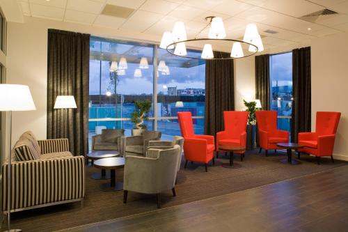 una sala de espera con sillas y mesas rojas y vistas en ibis Bristol Temple Meads, en Bristol