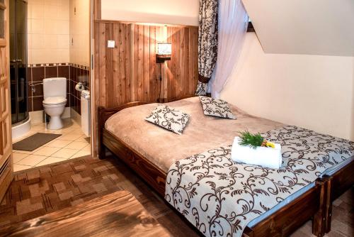 - une petite chambre avec un lit et une salle de bains dans l'établissement Madejowy Dwór, à Jurgów