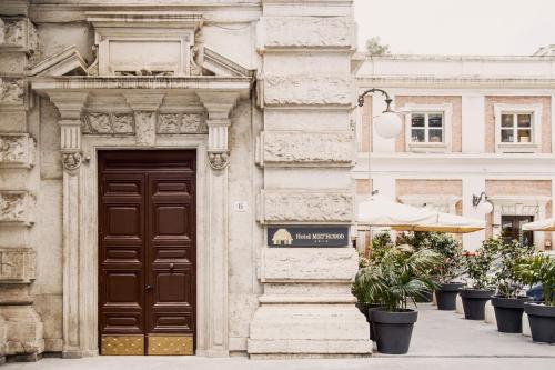 ナポリにあるBoutique Hotel Metro 900の茶色の扉と鉢植えの建物