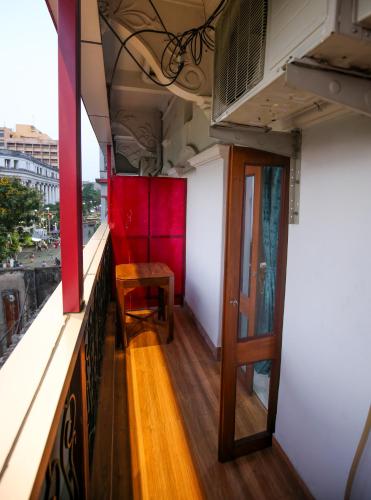a balcony with a table and a chair on a building at Hotel Cecil in Kolkata