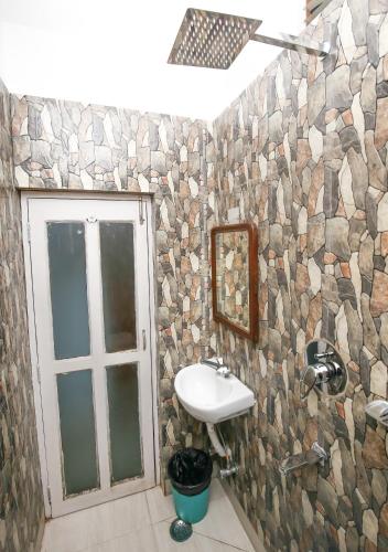 a bathroom with a sink and a mirror and a window at Hotel Cecil in Kolkata