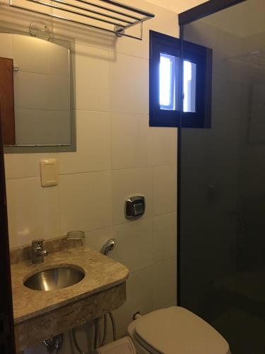 a bathroom with a sink and a toilet and a mirror at Hotel Domingo Savio in Encarnación