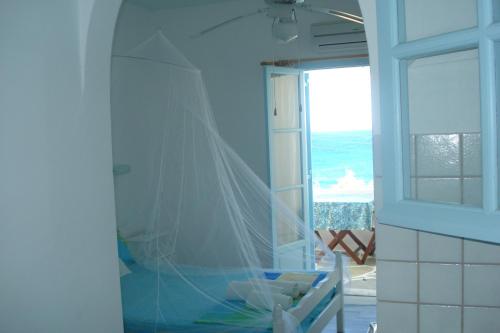 a bathroom with a shower with a veil on the wall at Paros Carmel studio-apartment in Logaras