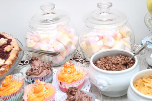 a table with cupcakes and other desserts in jars at DONNA LUCREZIA b&b Boutique Hotel Style - relax & business stay in Bisceglie