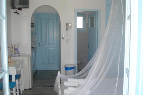 a bathroom with a white sink and a mirror at Paros Carmel studio-apartment in Logaras