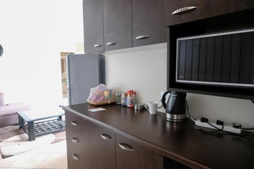 a kitchen with a counter top with a microwave at Beach Retreat Guesthouse in Amanzimtoti