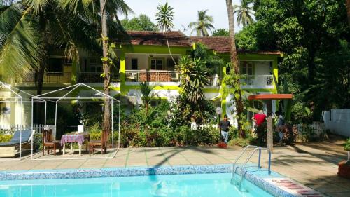 a house with a swimming pool in front of a house at CALANGUTE BEACH VILLA # 3BHk # POOL # KITCHEN # 300MTS TO BEACH by GR Stays in Calangute