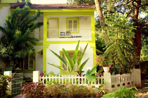 a yellow and white house with a white fence at CALANGUTE BEACH VILLA # 3BHk # POOL # KITCHEN # 300MTS TO BEACH by GR Stays in Calangute