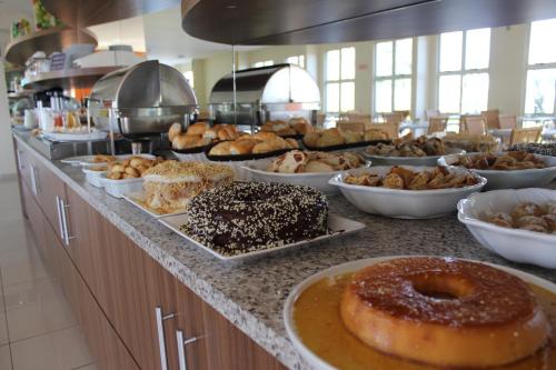 ein Buffet mit verschiedenen Arten von Donuts und Gebäck in der Unterkunft Villalba Hoteis in Londrina